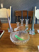 Table display of three glass Iittala candleholders with four taper candles in two, crystal bowl, and clear glass bowl with textural design.