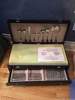 Box open showing lid, foam insert, two drawers filled with cutlery