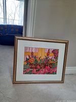 Full view of framed watercolor painting leaning against wall, showing mat and frame