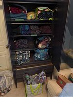 Full shelving unit with bags and folded items showing all yarn and sweaters