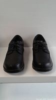 Front view of both black leather shoes side by side, lace-up style, size 9.