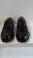 Front view of pair of black leather men's dress shoes with laces.