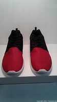 Front view showing red mesh toe box, black upper, and white sole of both shoes.