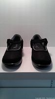 Front view of a pair of black Orthofeet ladies shoes showing mesh material and Velcro strap