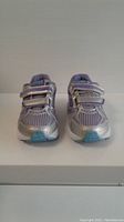 Front view of new Saucony kids running shoes size 11.5 showing silver mesh upper and lavender accents with two Velcro straps.
