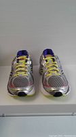 Front view of Saucony ladies running shoes size 10W in silver mesh with yellow laces and purple interior.