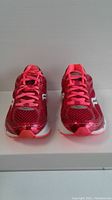 Front view of pair of red Saucony women's running shoes size 9, showing laces, tongue, and toe box detail.