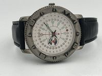 Close-up front view of the Dumia quartz wristwatch showing the dial with circular and triangular markers and the rotating bezel with numeric markings, along with the black leather strap.