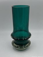Front view of vintage green glass vase with clear thick base on white background