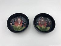 Top view of two Moorcroft pottery bowls showing interior floral and fruit motifs