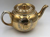 Side view of the Sadler tea pot showing gold finish, handle, spout, and crown emblem.