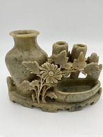 Front angle showing the main vase, floral carvings, and smaller cylindrical holders