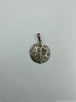 Front view of round sterling silver pendant with abstract overlay and mother of pearl.