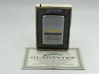 Front view of the vintage Zippo lighter with R. Angus Caterpillar logo in original box.