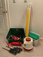 Full lot display showing green Coleman two-burner camp stove with red fuel tank, Aladdin cooler, Coleman Personal 8 cooler, yellow beach umbrella, two black Realistic walkie-talkies, red flashlight and accessories.