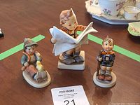 Three Hummel figurines on table showing all included items.