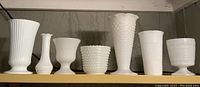 All seven vases lined up showing variety in styles including hobnail and fluted designs