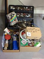 Wide shot showing boxes of plumbing parts, propane bottles, putty, valves, and solder supplies.