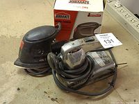 Jobmate Detail Sander and Craftsman 1/2 Sheet Orbital Sander placed side by side with Jobmate box behind.