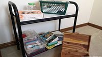 Overall lot view showing plastic basket with sewing supplies, cardboard boxes with attachments, cedar box, and metal shelf.