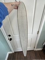 Back side of the wooden water ski sign showing natural wood grain.