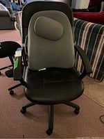 Front view of black faux leather desk chair with gray ObusForme lumbar backrest attached.