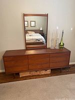 Front view of teak dresser and mirror against wall