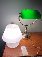 banker lamp and mushroom lamp side by side on wooden surface