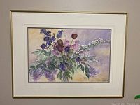 Framed watercolour painting showing flowers with a white mat and thin gold frame, signed by B.J. Webb.