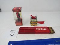Overview photo of lot showing the pencil set, mini soda crate, and figurine in packaging