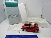 Overview of the Hallmark Kiddie Classic 1938 Lincoln red metal car with packaging, certificate, and ruler for scale.