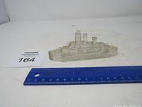 Clear glass ship figurine shown with ruler for size reference
