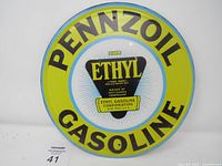 Front view of round metal Pennzoil Gasoline sign with Ethyl logo showing condition and artwork details.