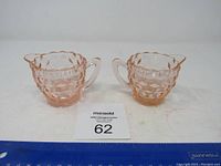 Front view of the two pink glass pieces, showing overall shape, texture and size comparison.