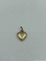 Heart-shaped 10kt gold pendant front view on white background.