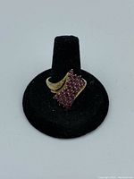 Front and top view of the vintage 925 silver ring with clustered small rubies set in abstract design on black velvet ring holder.