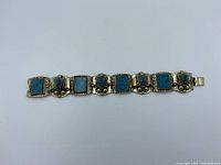 Front view of vintage sterling silver bracelet with square blue stones and silver decorative links.