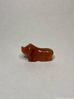 Side view of the carnelian pig statue on a plain background showing the full body profile and polished surface.