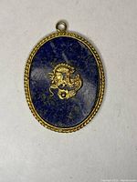 Front view showing lapis lazuli stone with gold dragon motif and twisted rope gold border
