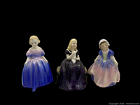 Front view of three Royal Doulton figurines Marie, Dinky Do, and Affection showing detailed dresses and poses