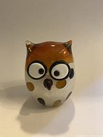 Front view of the solid glass owl figurine showcasing its large eyes, amber top head, and spotted white body.