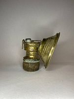Side view showing the cone-shaped brass reflector and wick adjustment mechanism on the miners lamp.