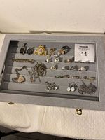 Full top-down view of the jewelry box displaying all pieces arranged neatly in rows on gray cushioned slots.