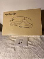 Closed box showing product line drawing and text 'Eye Massager'