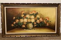 Full view of the oil painting framed, showing chrysanthemums in a vase with warm background tones.