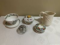 Five items displayed on table: Botanic Garden strawberry bowl and saucer, Godinger pitcher, Mikasa candy dish with fruit lid, Evansham Vale Royal Worcester lidded dish, and a glass and pewter potpourri dish.