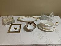 Photo showing full set of china and crystal tableware items including the hand painted dish, crystal napkin holder, jam jars, Limoges candy dish, hand painted candy dish, and Royal Albert gravy boat with tray.