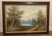 Full view of the framed oil painting showing forest with lake and sky.