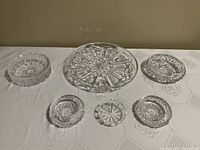 Top-down photo of all six pieces showing the various sizes and detailed cut glass patterns.