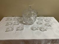 Full view of crystal punch bowl with lid and 12 matching cups, showing arrangement on table